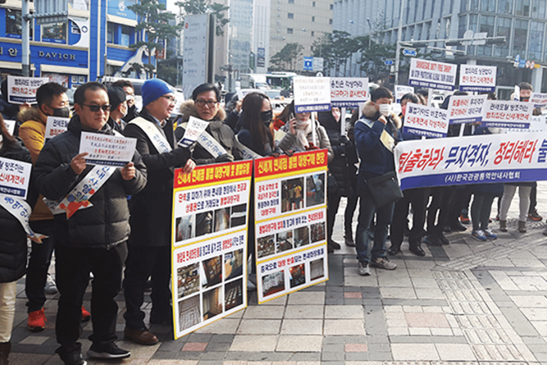 Korea Tourist Guide Association members hold pickets and brochures in front of Shinsegae Department Store Main Branch in downtown Seoul, Wednesday, criticizing Shinsegae Duty Free for allegedly selling to foreigners who redistribute tax-free goods illegally. Photo: Park Jae-hyuk/Korea Times