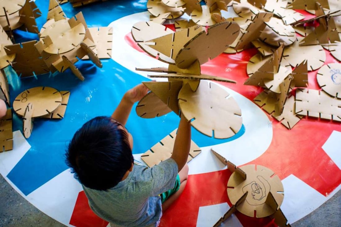 A child works with cardboard at Makerbay, PMQ, Central.