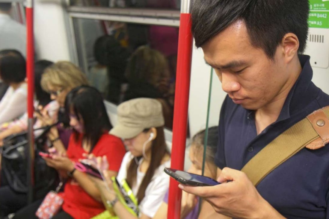 Passengers on the Hong Kong MTR glued to their smartphones. Photo: Alamy Stock Photo