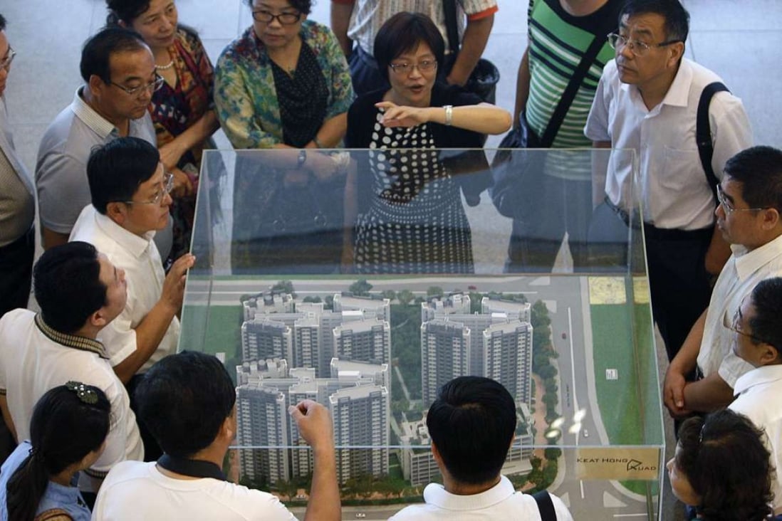 Explaining how it’s done: A group of visitors from China listen as their guide speaks about Singapore’s public housing policy. Photo: Reuters
