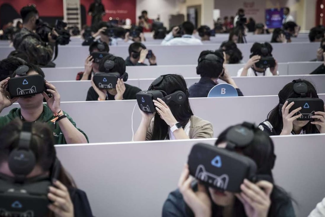 Members of the media wear virtual reality headsets featuring the Tmall Cat, mascot for Alibaba Group Holding Ltd.'s Tmall online marketplace, at Alibaba's annual November 11 Singles' Day online shopping event in Shenzhen. Photo: Bloomberg