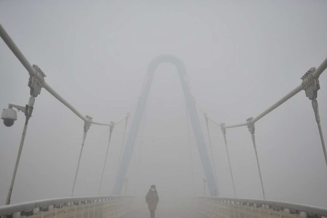 A woman wears a mask as she crosses a bridge in Tianjin on Monday. Photo: Reuters