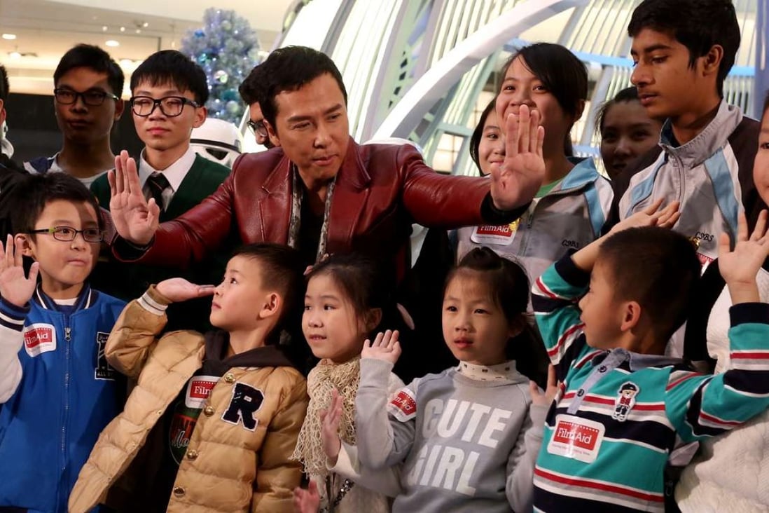 Actor Donnie Yen with some of the 300 underprivileged children treated to a special screening of the new Star Wars film. Photo: Jonathan Wong