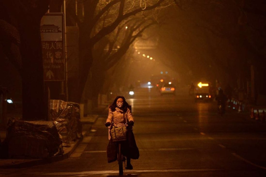 A woman rides along a Beijing street in heavy air pollution on December 20. More heavy smog is forecast for northern China until around January 5. Photo: AFP