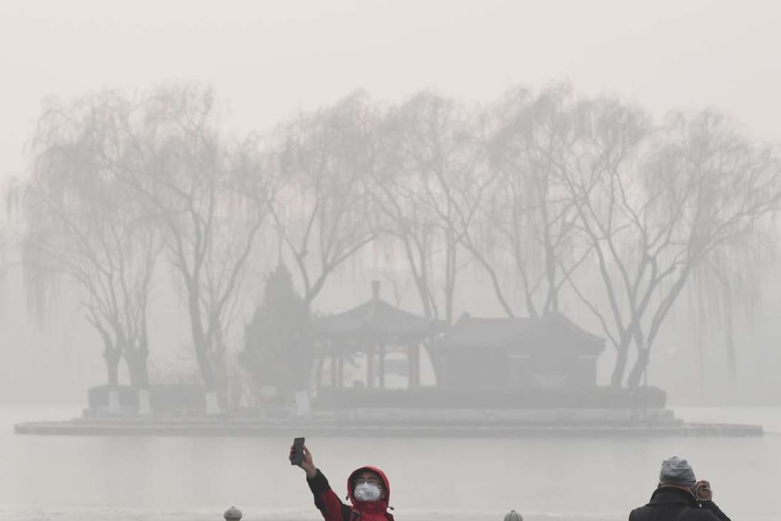 A man takes a selfie beside a lake on a heavily polluted day in Beijing on January 1. Photo: AFP