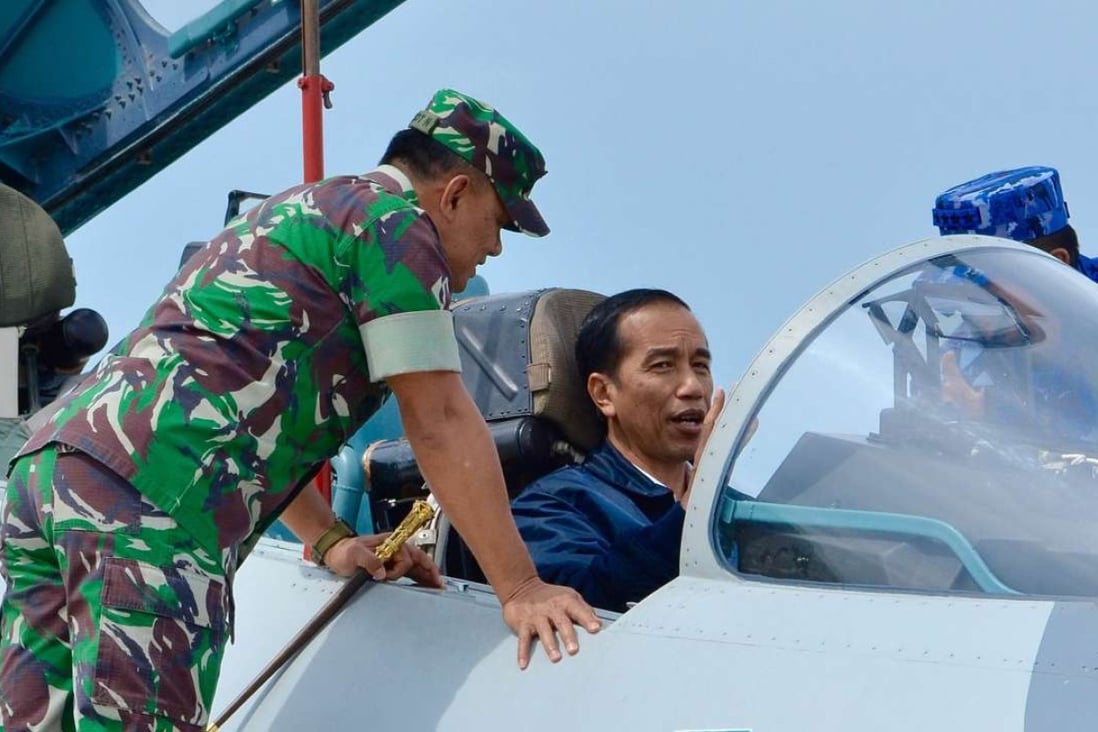 Indonesian President Joko Widodo sits in the cockpit of a Sukhoi Su-30 aircraft next to his military chief Gatot Nurmantyo. Photo: AFP