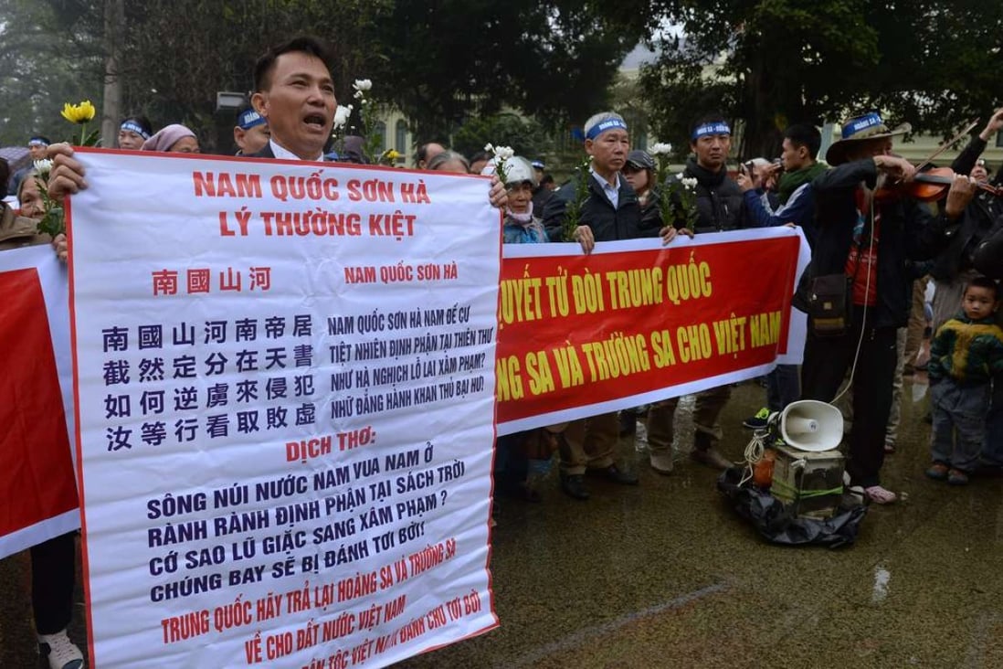 An anti-China activist holds a banner with Vietnam's 11th century general hero Ly Thuong Kiet's poem on Vietnam's determination to defend its independence, during a rally marking the anniversary of the 1974 naval battle between China and then-South Vietnamese troops over the Paracel Islands, in Hanoi. Photo: AFP