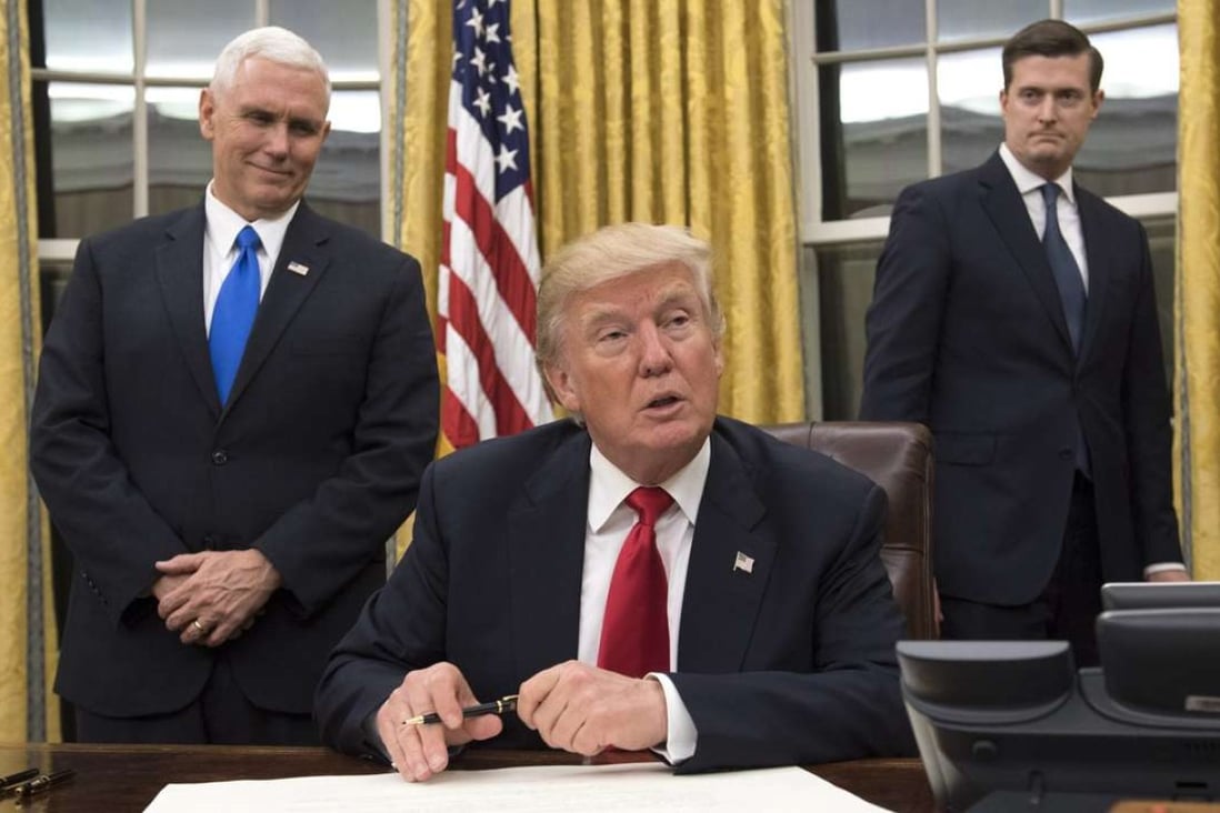 US President Donald Trump (centre) sits in the Oval Office at the White House after his inauguration on Friday. Photo: EPA