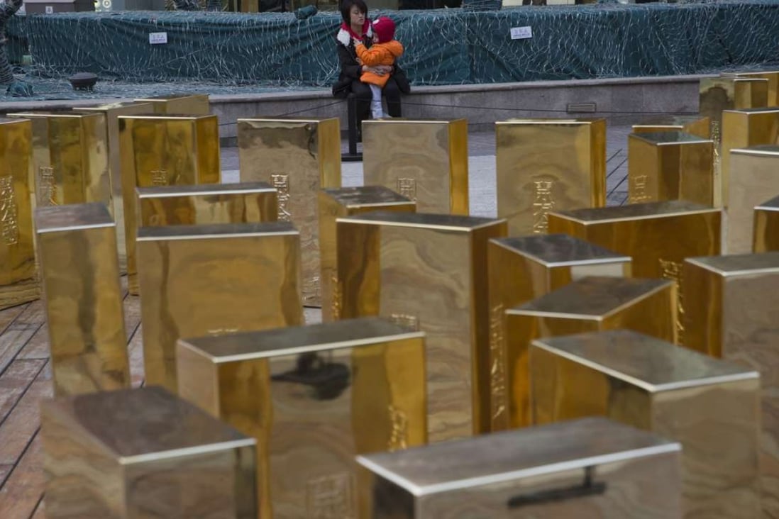 China’s gold appetite surged in 2016 as the yuan softened against global currencies. Replica gold bars are displayed at a mall in Beijing. Photo: AP