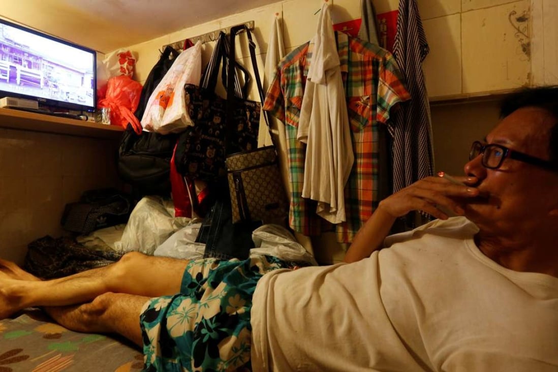 A Hong Kong man watches TV inside his “coffin unit”, with a monthly rent of HK$1,750. Photo: Reuters