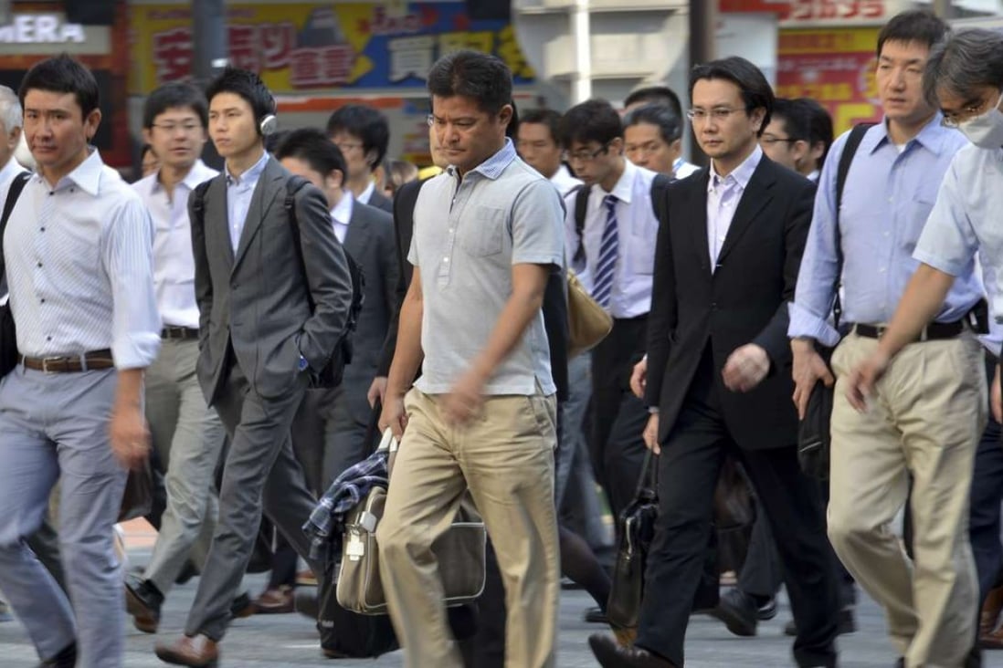 Japanese businessmen walk to their offices in Tokyo. Photo: AFP