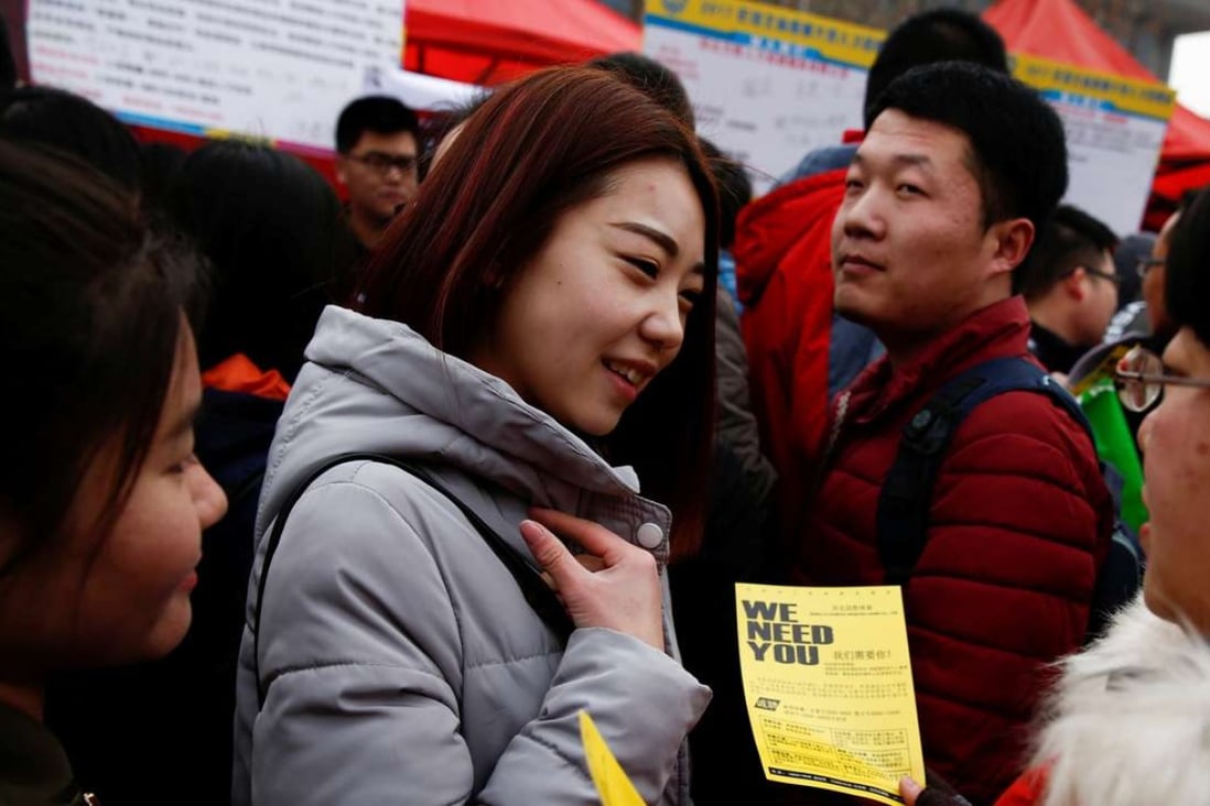 A recruiter hands out a flyer at an employment fair for college graduates in Shijiazhuang, Hebei province. Photo: Reuters