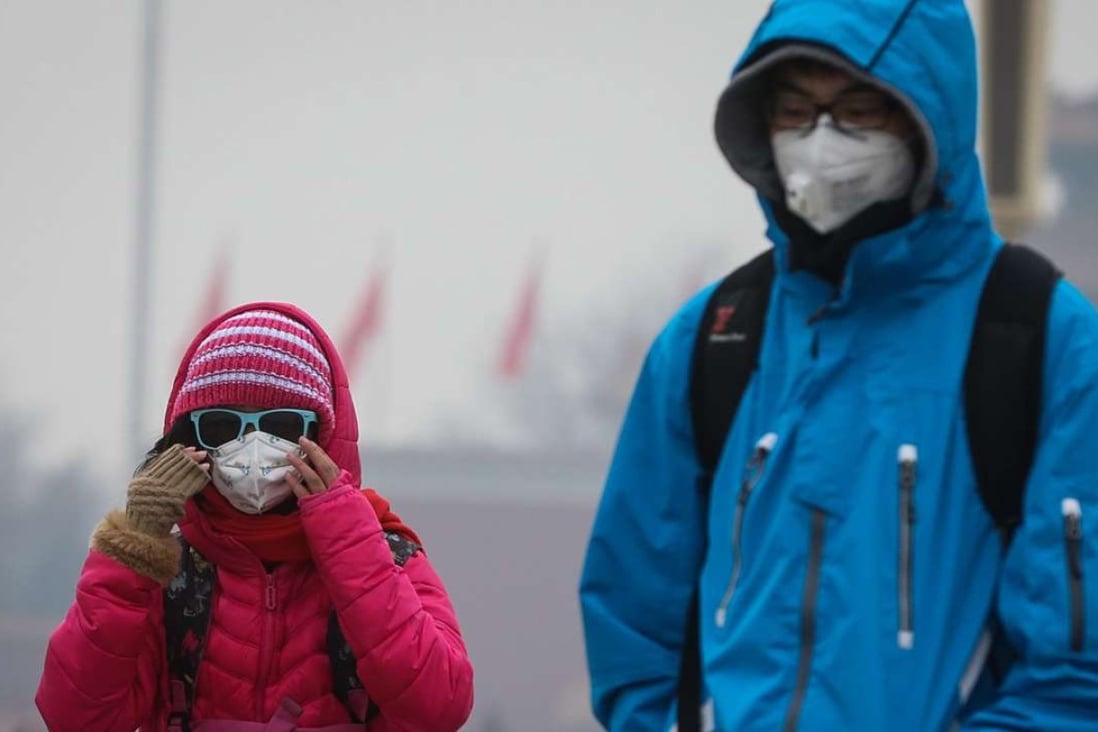 Tourists pictured wearing protective masks while visiting Tiananmen Square in Beijing last month. Photo: EPA
