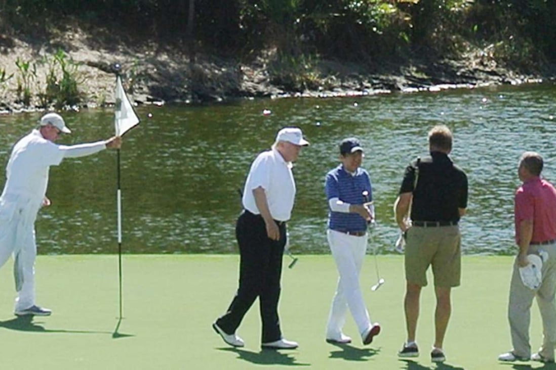 US President Donald Trump, second from left, and Japan's Prime Minister Shinzo Abe, centre, play a round of golf in Florida. Photo: AFP