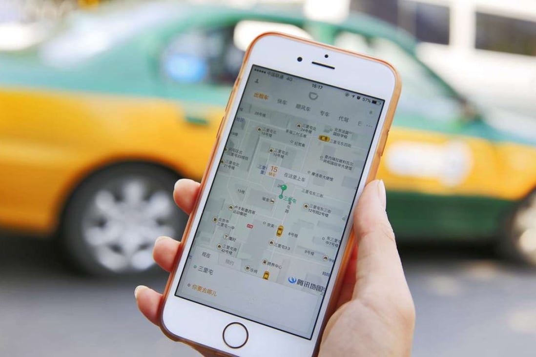 A commuter shows the Didi Chuxing app on her iPhone in Beijing. The dominant ride-hailing application has begun testing an interface in English, and has begun to accept international credit cards for the first time. Photo: EPA