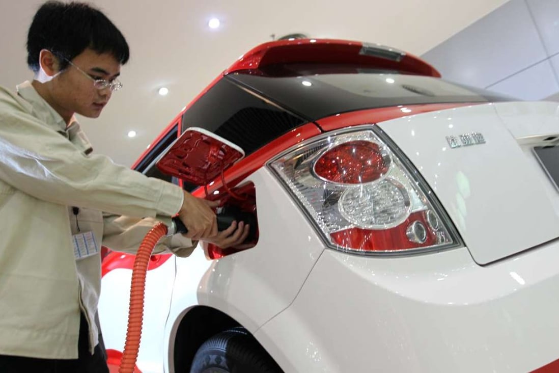 A BYD worker connects the charger for an electric taxi at the company’s showroom in Shenzhen. Photo: May Tse