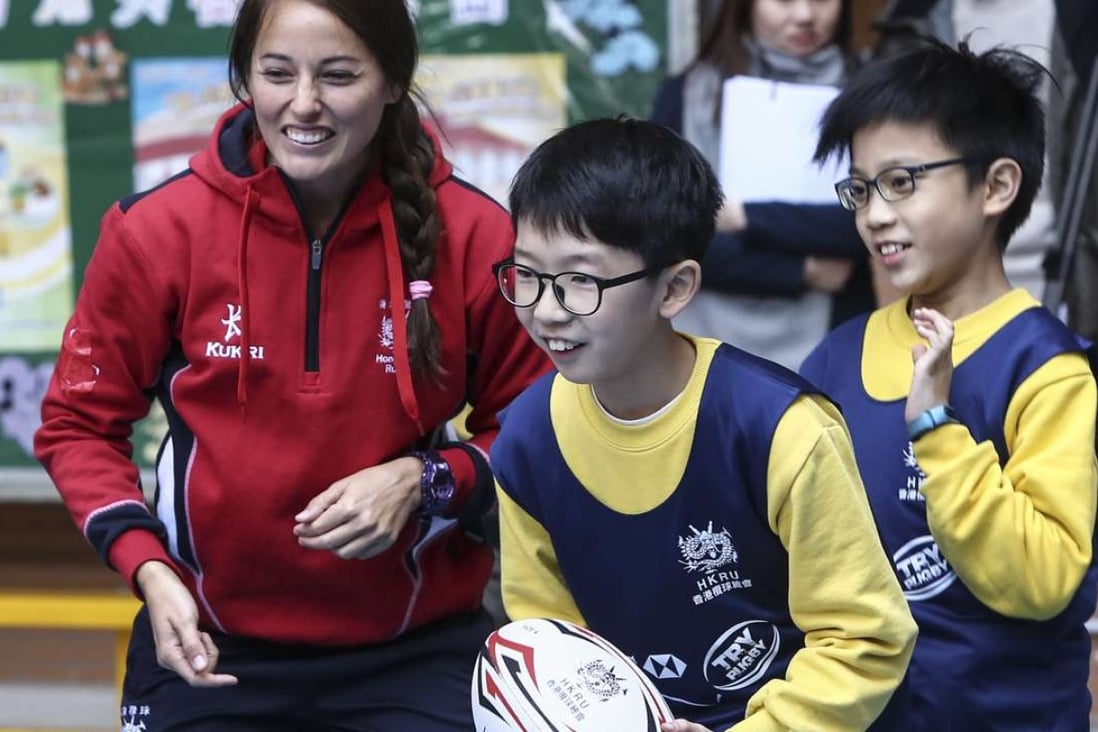 Hong Kong player Lindsay Varty teaches students from SKH St James’ Primary School how to play rugby. Photos: Jonathan Wong