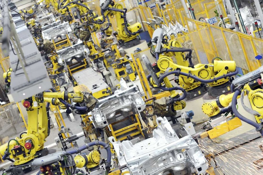 Robot arms weld car parts at an auto plant in Wuhan.