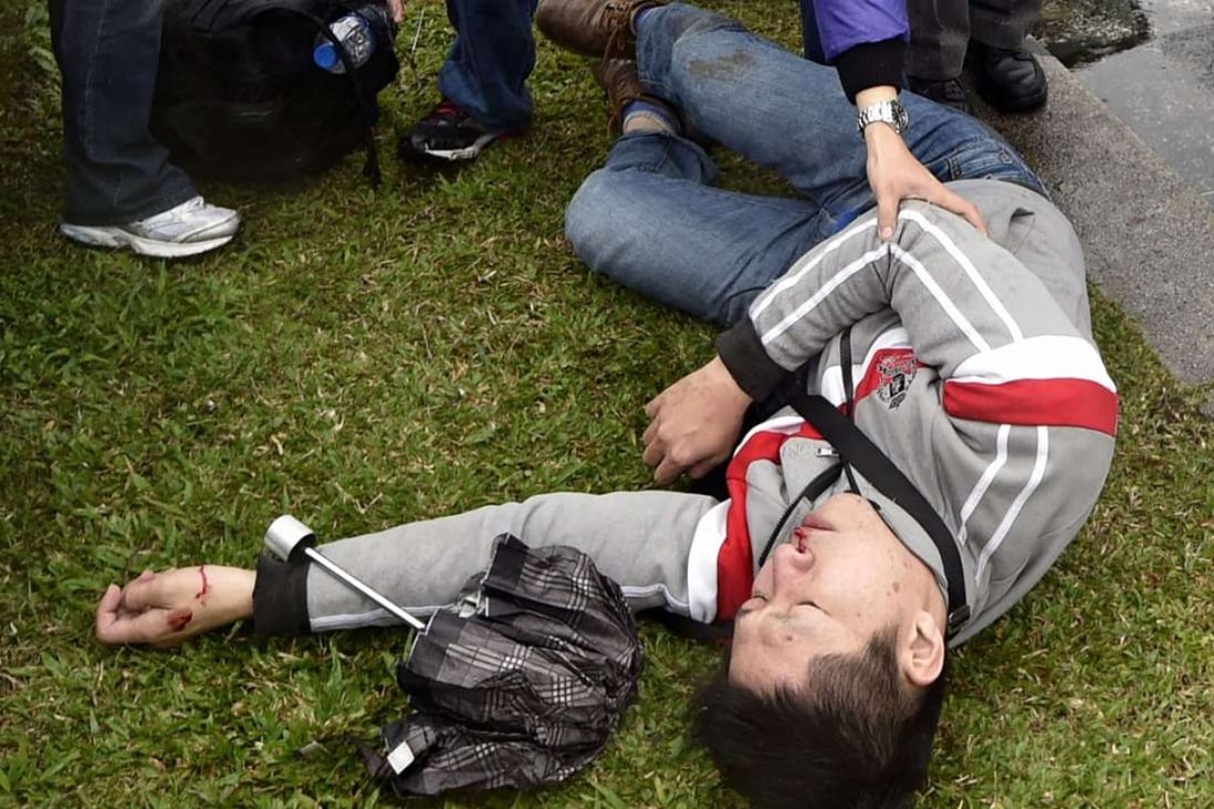 An injured man lies on the ground after clashes between pro-independence and pro-unification groups during the 70th anniversary of the 228 incident at the Chiang Kai-shek Memorial Hall in Taipei on Tuesday. Photo: AFP