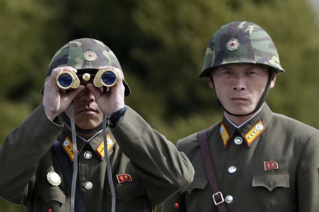 A North Korean soldier looks at the southern side through binoculars at the border village of the Panmunjom. Photo: AP