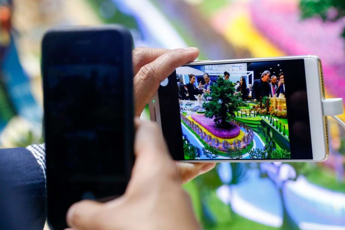 An attendee uses a smartphone to take a photograph of an Axon 7 smartphone, manufactured by ZTE Corp, on the opening day of the Mobile World Congress (MWC) in Barcelona on Monday. Photo: Bloomberg