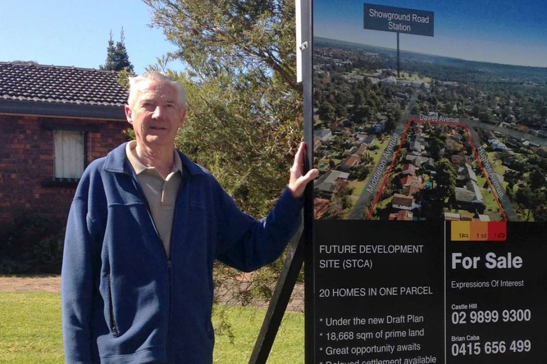Sydney resident Ron Buxton poses with his home's for-sale sign in the suburb of Castle Hill, Sydney, Australia. Photo: Reuters