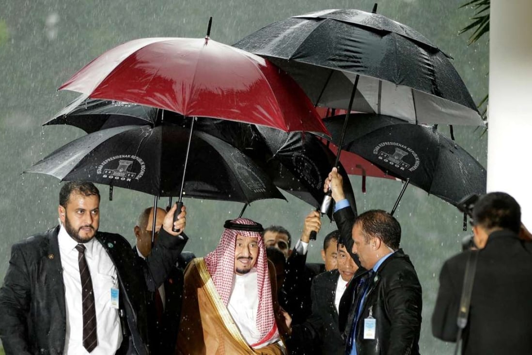 Saudi King Salman is sheltered from the rain upon his arrival at the presidential palace in Bogor, West Java. Photo: AFP
