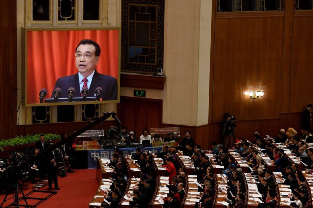 Chinese Premier Li Keqiang is shown on a screen as he delivers his work report during the opening session of the National People's Congress, China's legislature, in Beijing's Great Hall of the People on March 5, 2017. Photo: AFP