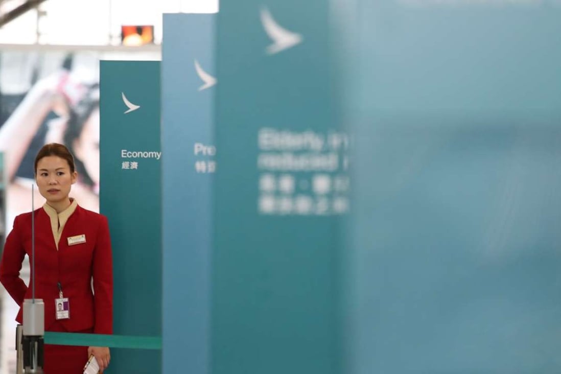 A Cathay Pacific flight attendant at the airline’s check-in counters at the Hong Kong International Airport. Photo: Nora Tam