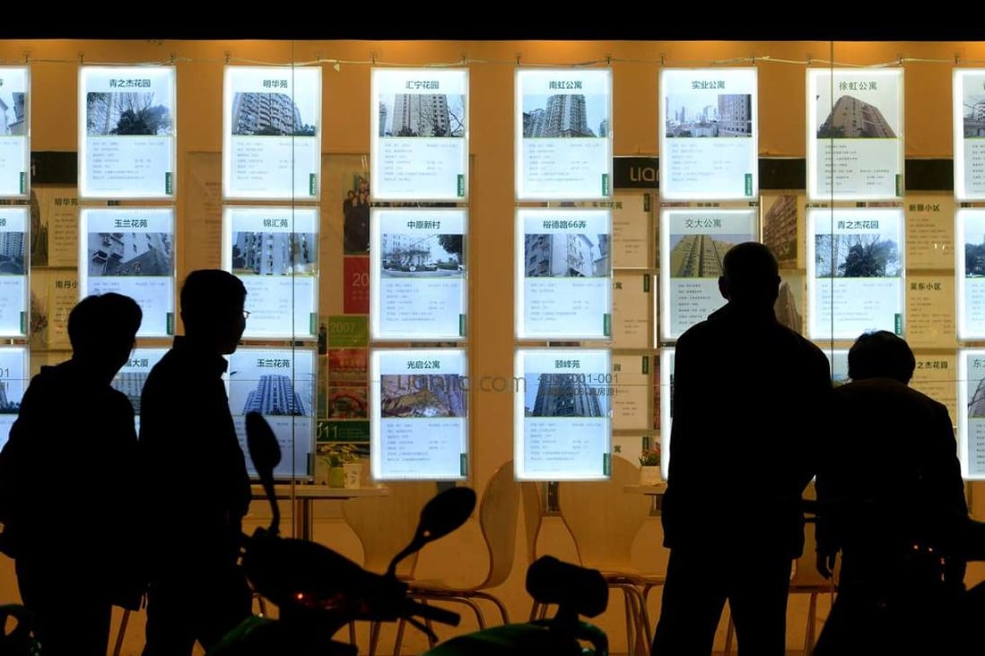 Potential buyers look at the real estate advertisements posted on the windows of a shop of Lianjia, one of China's biggest real estate brokerage agencies, in Shanghai. Photo: Lai Xinlin)