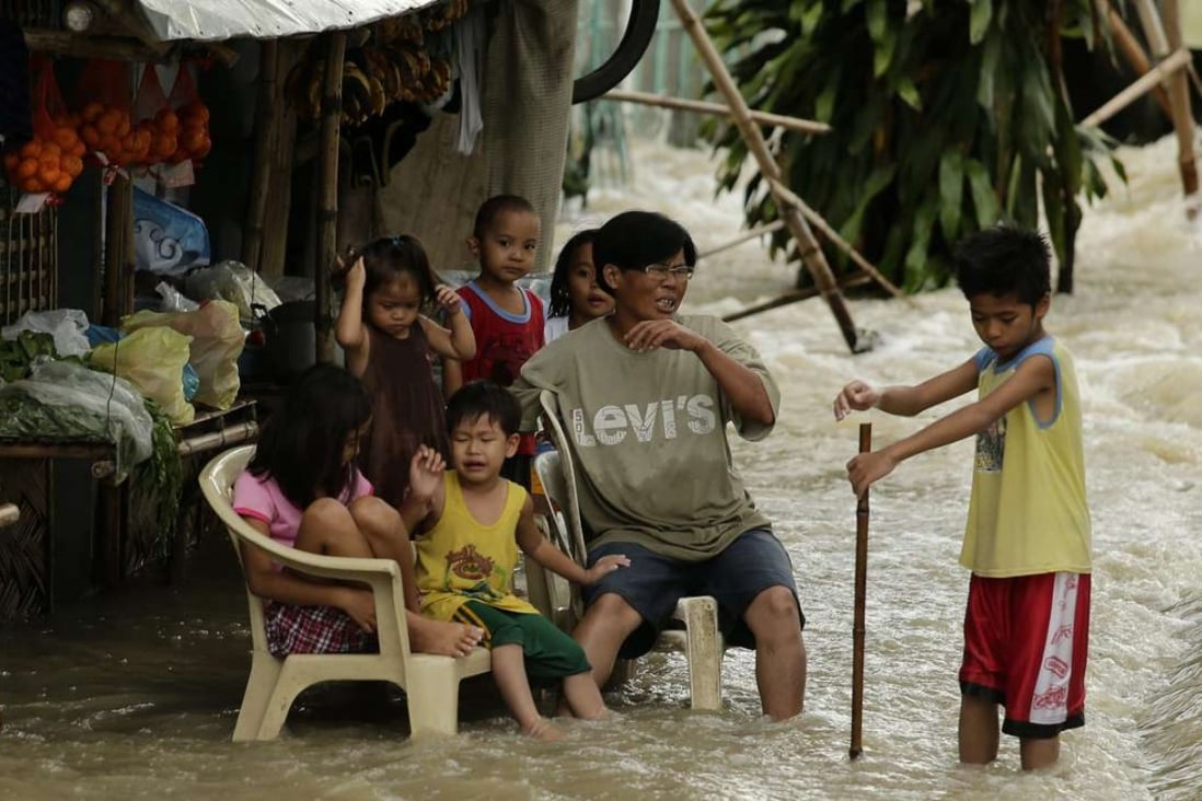 Villagers sit amid floodwaters in the typhoon-hit town of La Paz, Tarlac province, in southern Manila on December 17, 2015. The frequency of extreme weather will increase in line with global temperatures. Photo: EPA