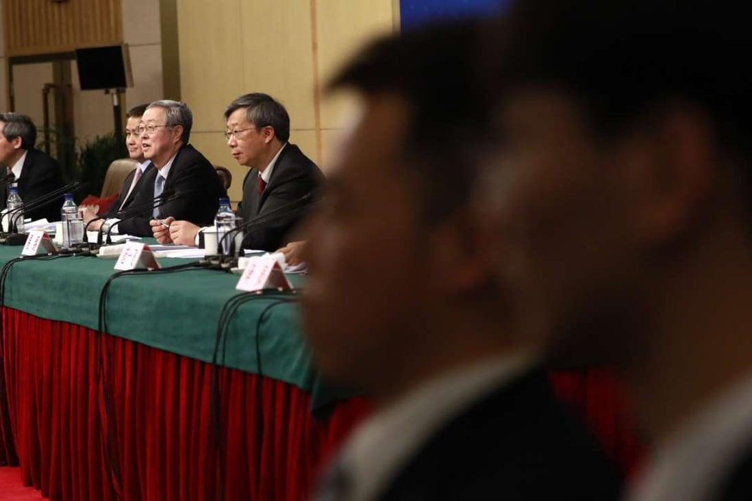Central bank governor Zhou Xiaochuan (third from left) speaks to reporters during a press conference on the sidelines of the National People’s Congress meeting. For the first time, he publicly condemned exuberant overseas deal-making by Chinese firms, further justifying China’s capital controls. Photo: EPA