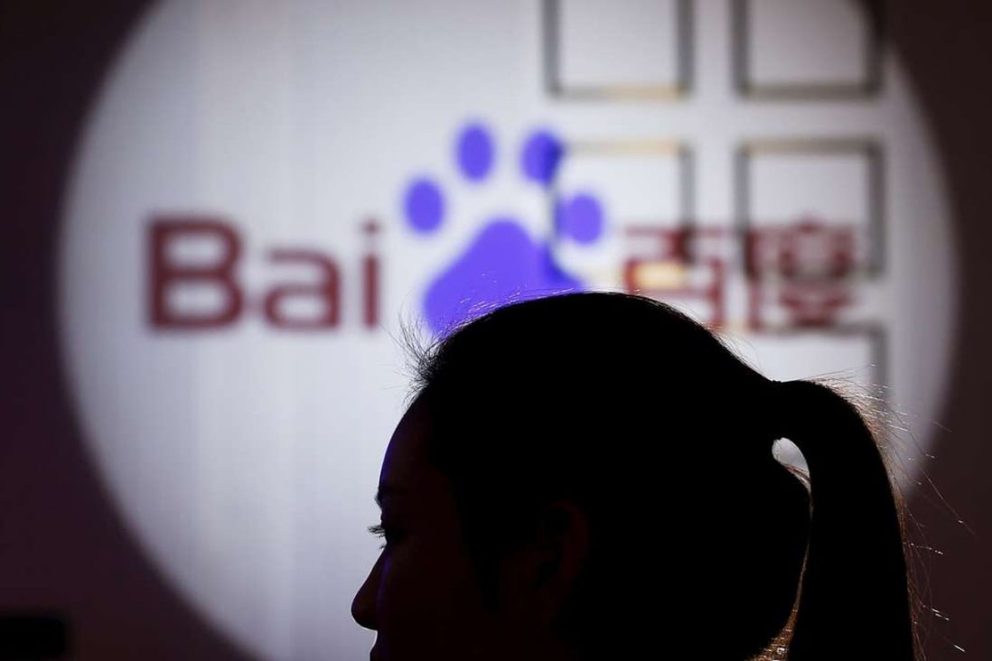 A woman is silhouetted against the Baidu logo at a new product launch from Baidu, in Shanghai. Photo: Reuters
