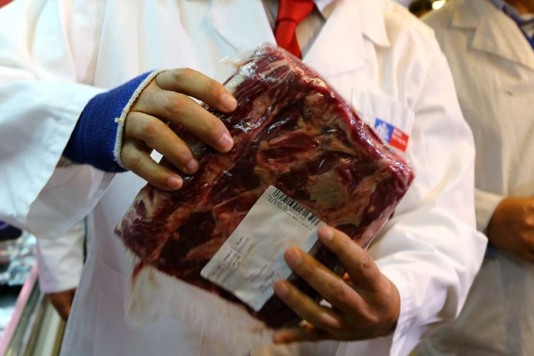 A member of the Chile’s Public Health Surveillance Agency inspects a piece of beef. Photo: Reuters