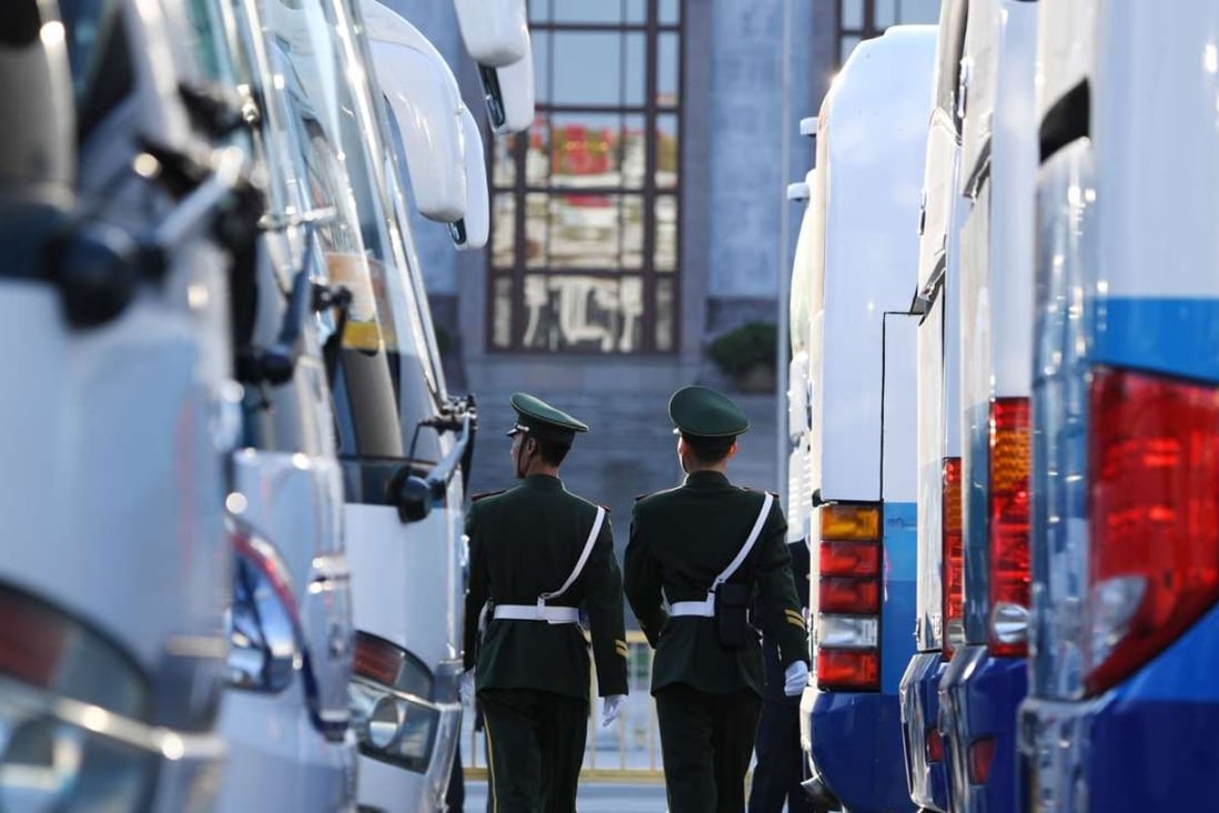 Paramilitary police officers patrol between delegates' buses during the 2nd second plenary session of the National People's Congress in Beijing. More than 3000 delegates from across China are attending the annual meeting of the country's congress. Photo: AFP