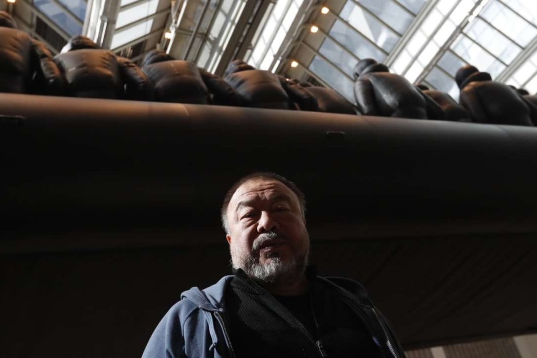 Chinese activist and artist Ai Weiwei poses by his installation displayed at the National Gallery in Prague, Czech Republic featuring a 70-metre-long inflatable boat with life-size figures of 258 refugees prepared for the gallery. Photo: AP