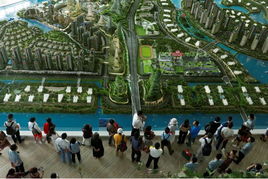 Prospective buyers look at a model of the development at the Country Gardens' Forest City showroom in Johor Bahru, Malaysia. Photo: Reuters