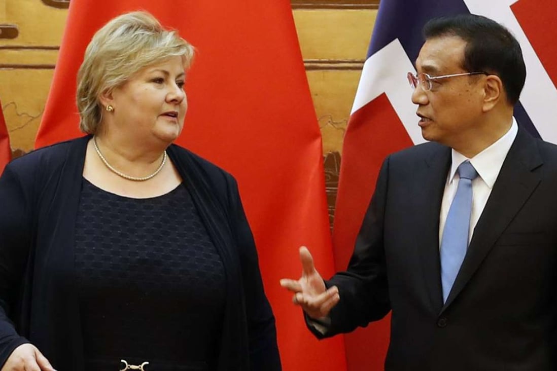 Chinese Premier Li Keqiang speaks to Norwegian Prime Minister Erna Solberg as they attend a signing ceremony at the Great Hall of People in Beijing on Thursday. Photo: EPA