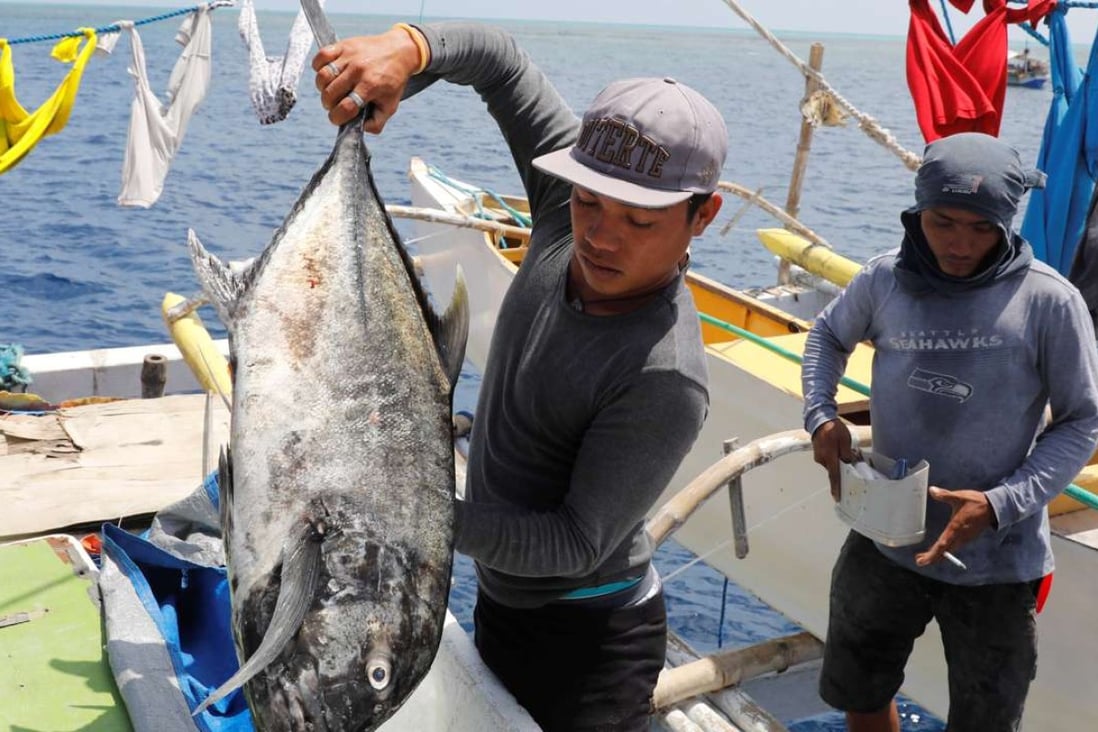 A Philippine fisherman prepares to weigh a fish at the disputed Scarborough Shoal. Photo: Reuters
