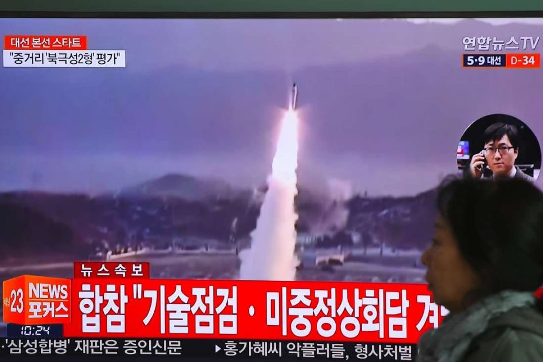 A woman walks past a television screen in Seoul, South Korea, showing file footage of a North Korean missile launch on Wednesday. The North fired a ballistic missile into the Sea of Japan that day, just ahead of the China-US summit in Florida. Photo: AFP