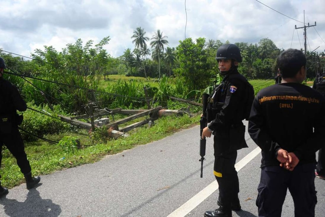 Thai Navy rangers survey the scene where a high voltage tower was blown up on a rural road in Bachoc district in Thailand's restive southern province of Narathiwat. Photo: AFP