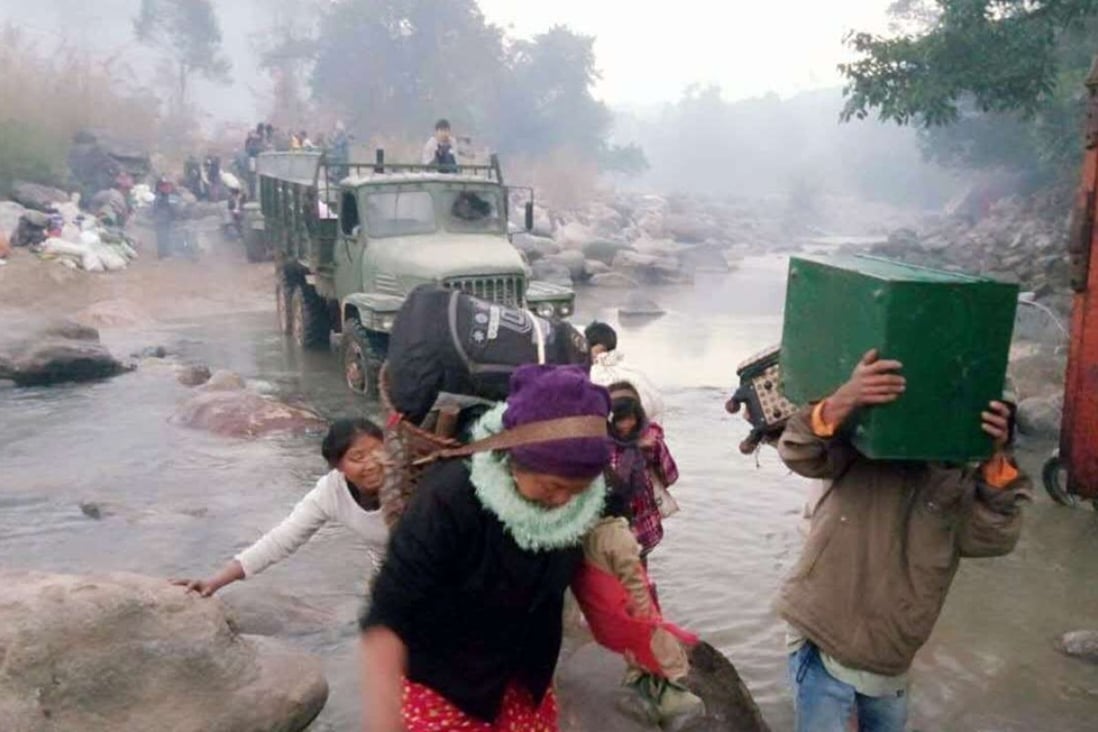 Refugees from fighting between Myanmar government forces and ethnic rebels cross a river on the border with Yunnan province in January. Photo: AFP