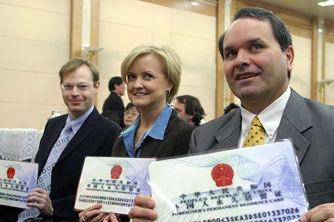 A file picture of foreigners holding larger, display copies of the old permanent residency cards. Photo: Handout