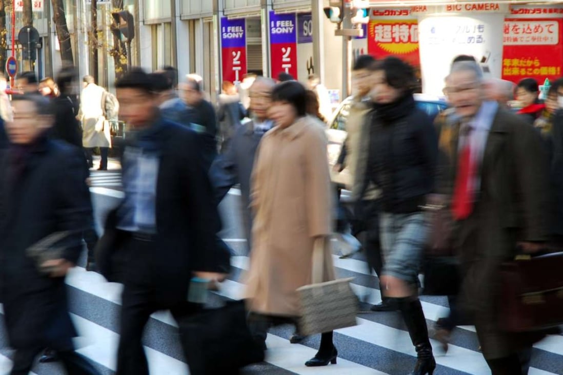 Commuters cross an intersection in downtown Tokyo. Photo: AP