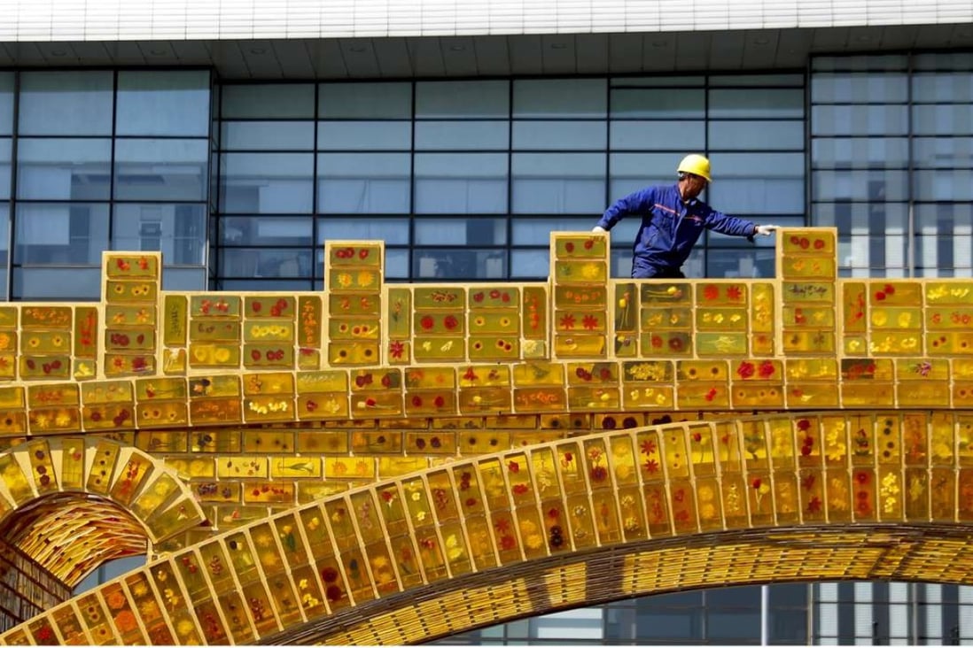 A worker walks along a “Silk Road Golden Bridge”, on display outside the National Convention Centre in Beijing, the venue which will hold the Belt and Road Forum for International Cooperation in May. India’s apprehension that the belt and road will merely serve China’s interest shows that New Delhi underestimates the transformative potential of the project. Photo: AP