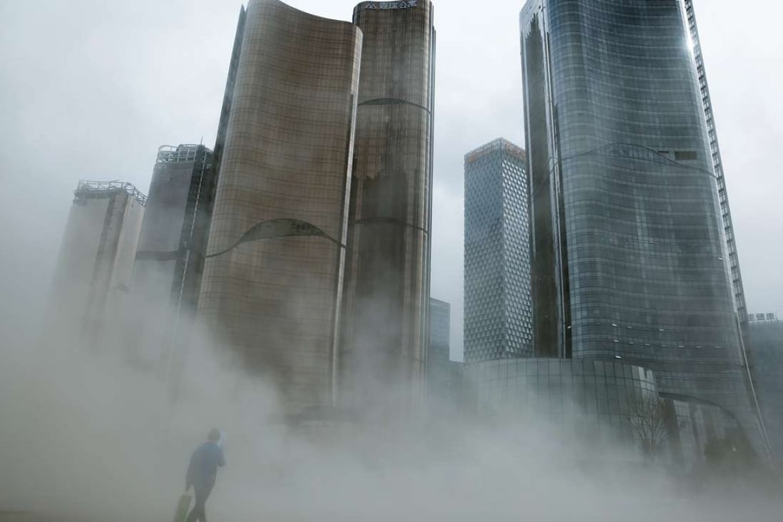 A man walks through a cloud of dust whipped up by wind at the construction site near newly erected office skyscrapers in Beijing. Developers are turning to alternative financing models. Photo: Reuters