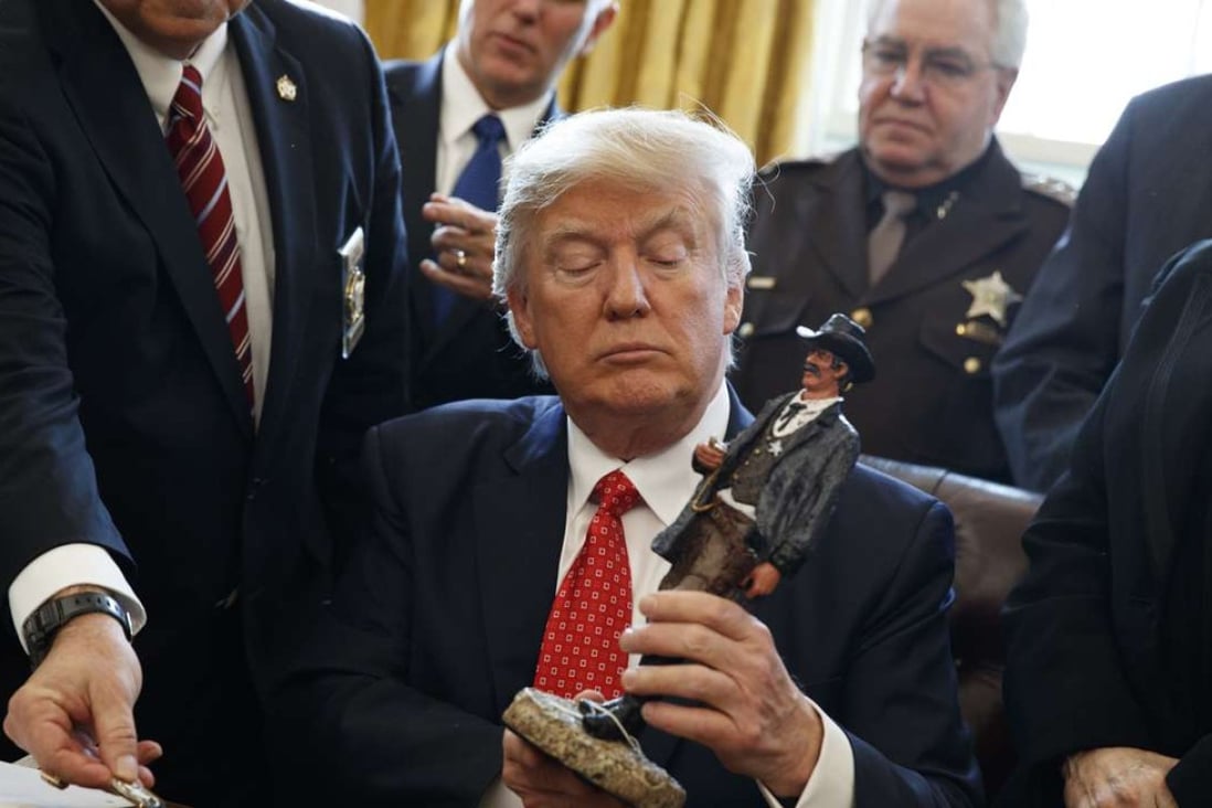 US President Donald Trump receives a figurine from a group of county sheriffs. Photo: AP