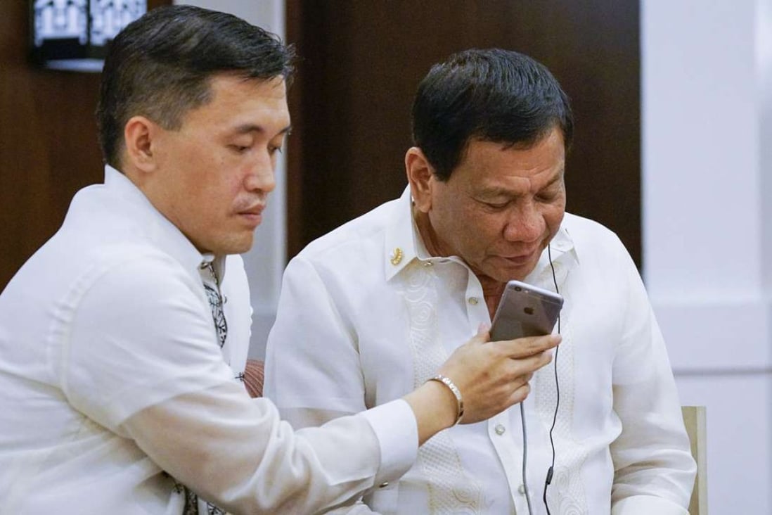 President Rodrigo Duterte, assisted by Special Assistant to the President Christopher Lawrence Go, speaks to US President Donald Trump. Photo: EPA