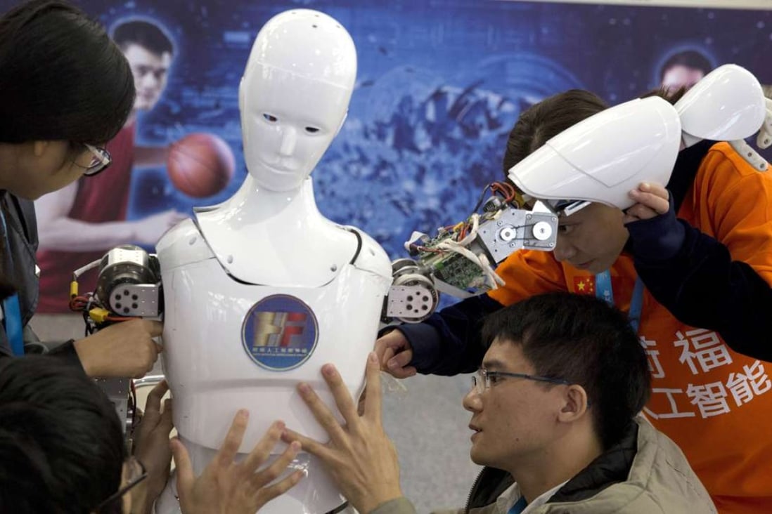 Chinese students work on a humanoid robot designed by them with funding from a Shanghai investment company, at the World Robot Conference in Beijing, last October 21. Photo: AP