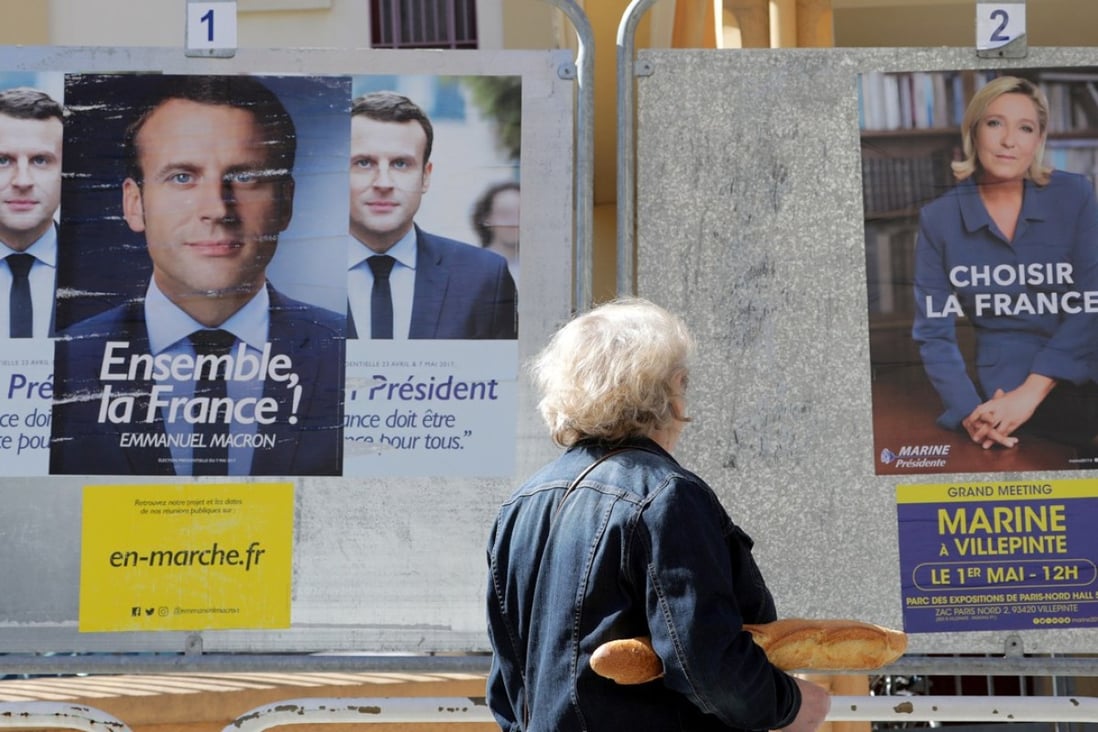 A woman walks past new official posters for the candidates in the 2017 French presidential election, Emmanuel Macron (L), head of the political movement En Marche !, or Onwards !, and Marine Le Pen (R) of French National Front (FN) political party, in Nice, France, on May 2, 2017. Photo: Reuters